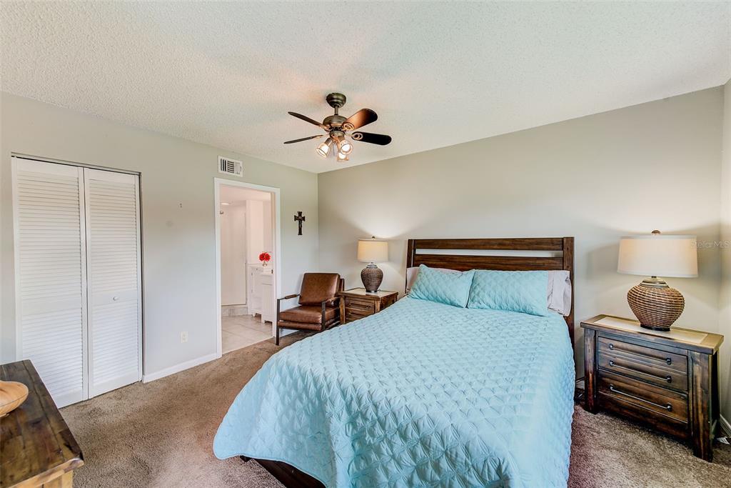 12900 Vonn Road, Unit E205 Largo, FL 33774 - Photo 15 of 35 a bedroom with a bed and a chandelier