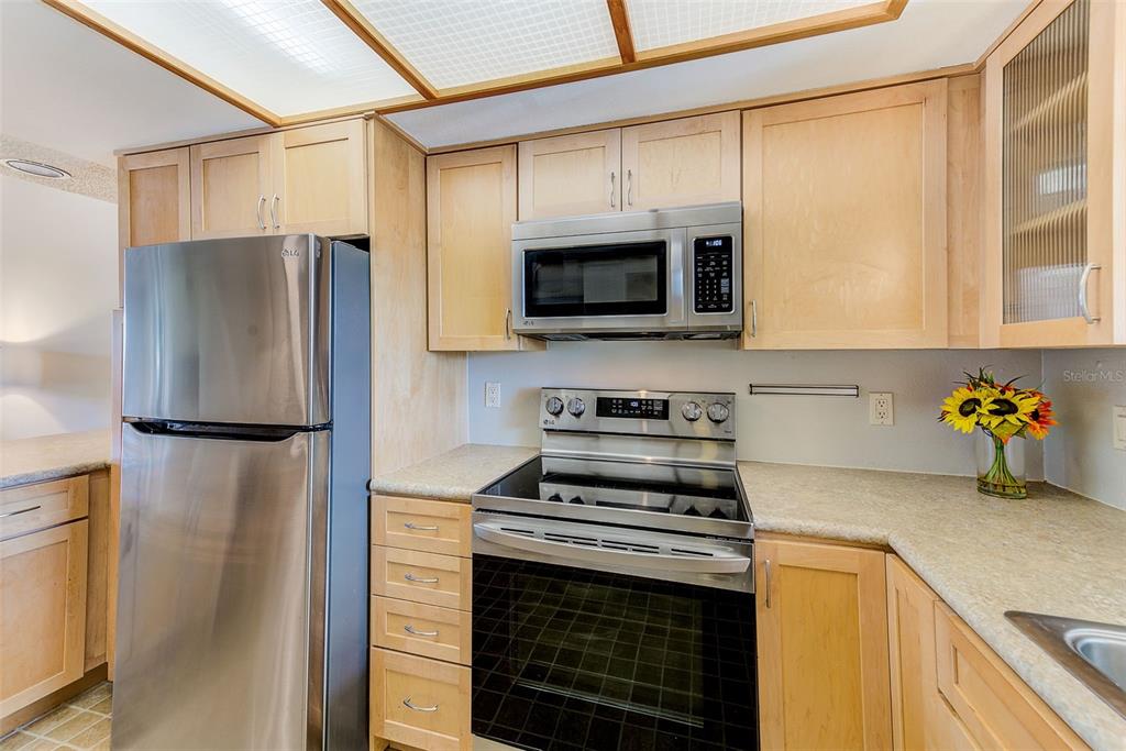 12900 Vonn Road, Unit E205 Largo, FL 33774 - Photo 6 of 35 a kitchen with a refrigerator stove and microwave