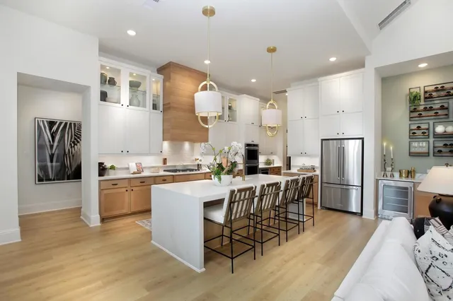 a kitchen with kitchen island a large counter top space stainless steel appliances and wooden floor