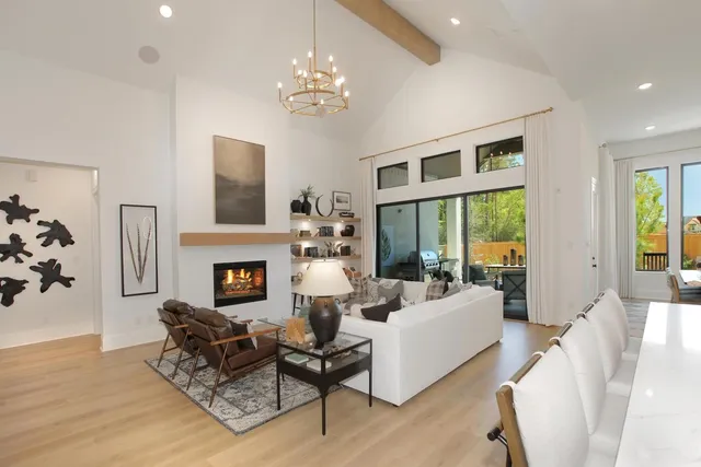 a living room with furniture a fireplace and a chandelier