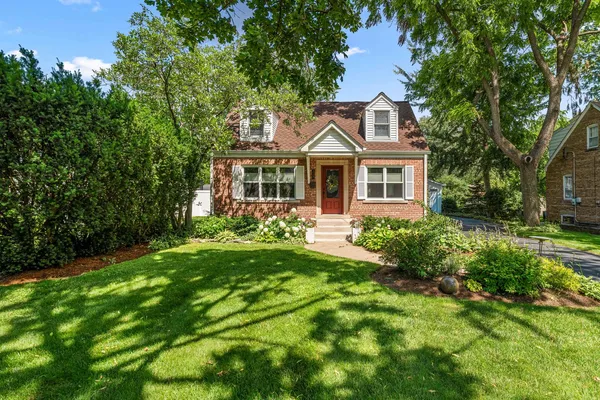 a front view of a house with a yard and trees