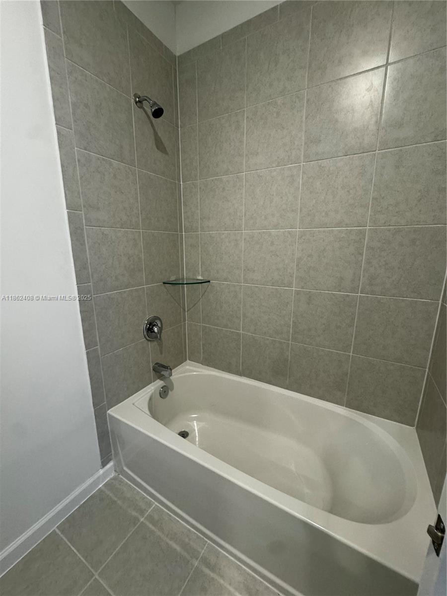 2325 Northwest 125 Street, Unit 2325 Miami, FL 33167 - Photo 18 of 18 a white bath tub sitting next to a white sink and vanity