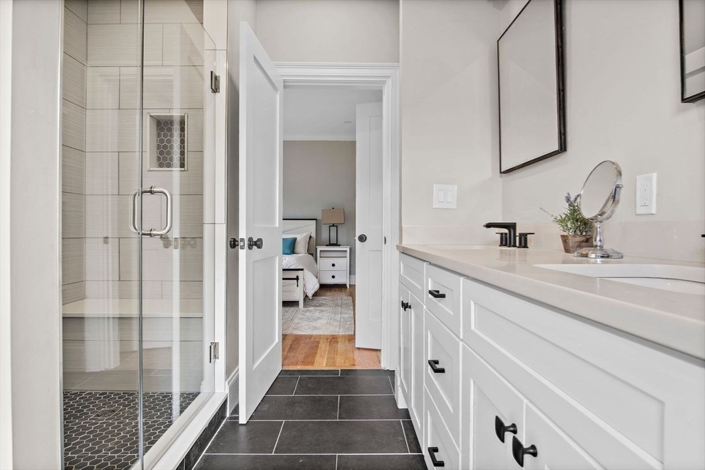 43 Samoset Road Woburn, MA 01801 - Photo 12 of 30 a bathroom with a double vanity sink a mirror and a shower