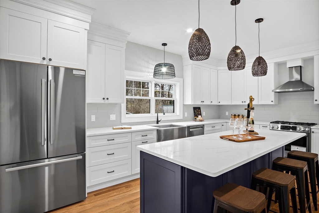 43 Samoset Road Woburn, MA 01801 - Photo 4 of 30 a kitchen with stainless steel appliances granite countertop a sink a refrigerator and a stove