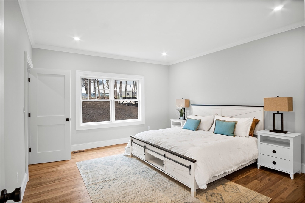 43 Samoset Road Woburn, MA 01801 - Photo 9 of 30 a bedroom with a large bed and wooden floor