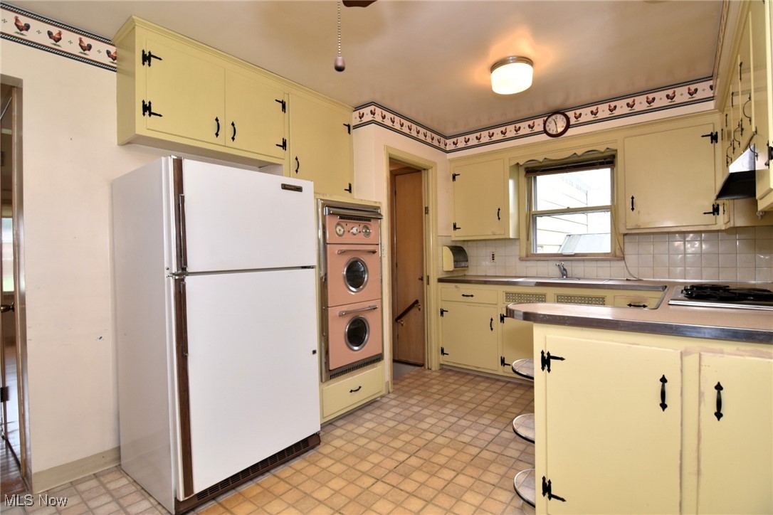 9421 David Road Cleveland, OH 44125 - Photo 13 of 36 Kitchen with freestanding refrigerator, cream cabinetry, and black stovetop