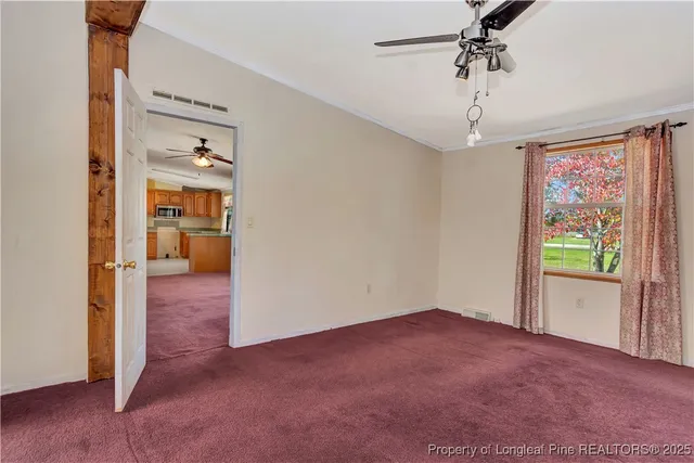 a view of a room with a ceiling fan and a window