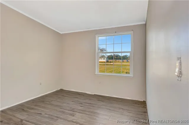 a view of an empty room with wooden floor