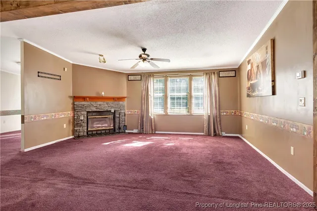 a view of an empty room with a fireplace and a window
