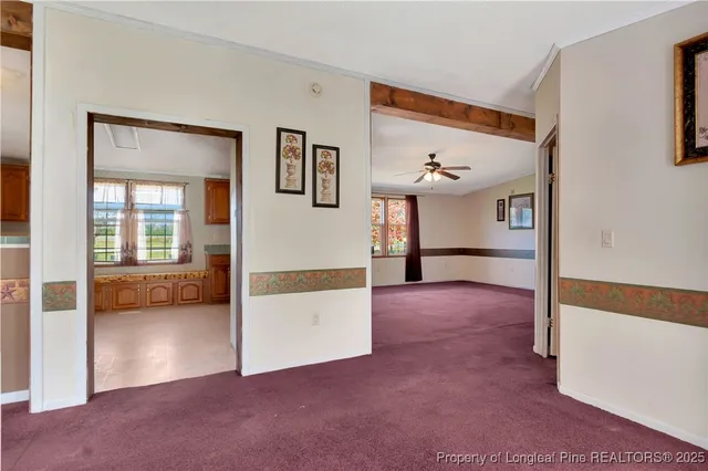 a view of a livingroom with furniture and a hallway
