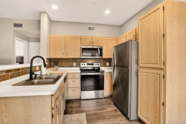 a view of a kitchen cabinets a bed and wooden floor