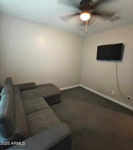 a living room with furniture and a ceiling fan