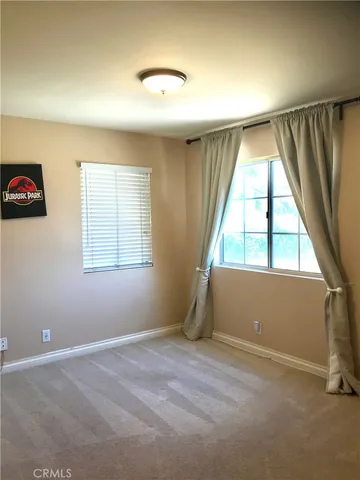 an empty room with windows and painted walls