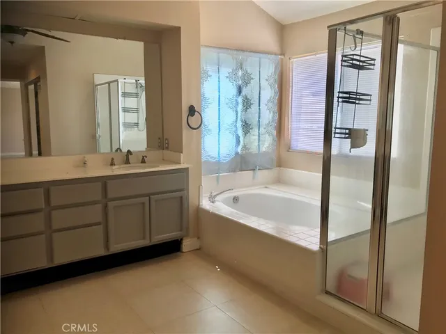 a spacious bathroom with a bathtub sink and mirror