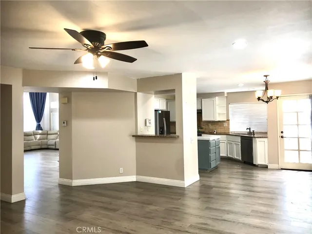 a view of a living room and kitchen with wooden floor