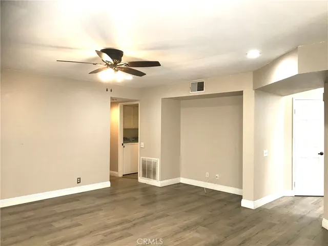 a view of an empty room with wooden floor