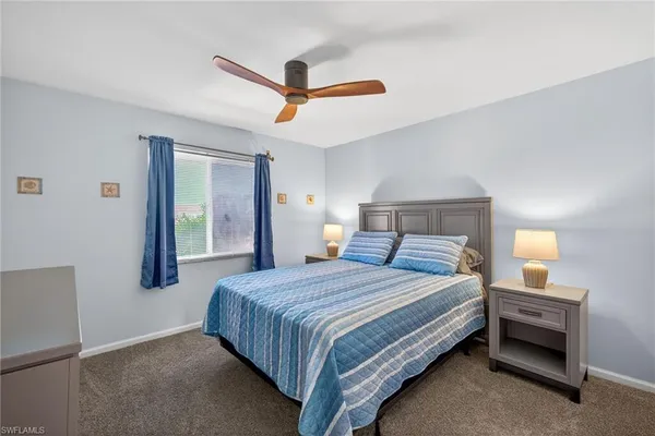 a bedroom with a bed and a ceiling fan