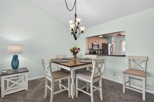 a view of a dining room with furniture a chandelier and wooden floor