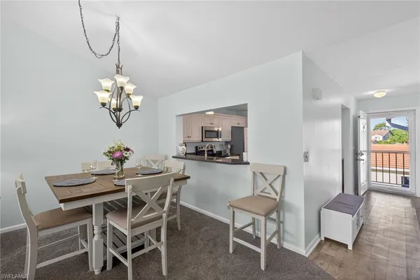 a dining room with furniture a chandelier and wooden floor