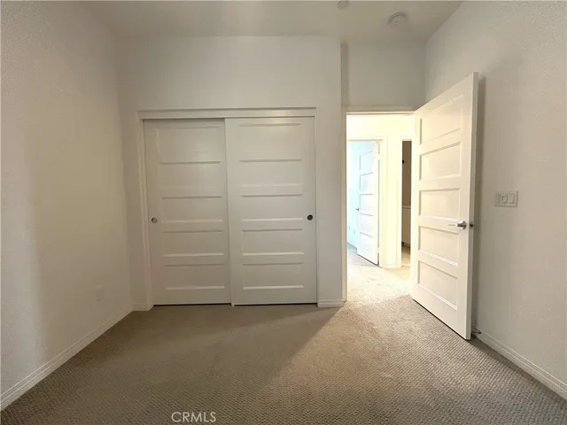 an empty room with closet and natural light