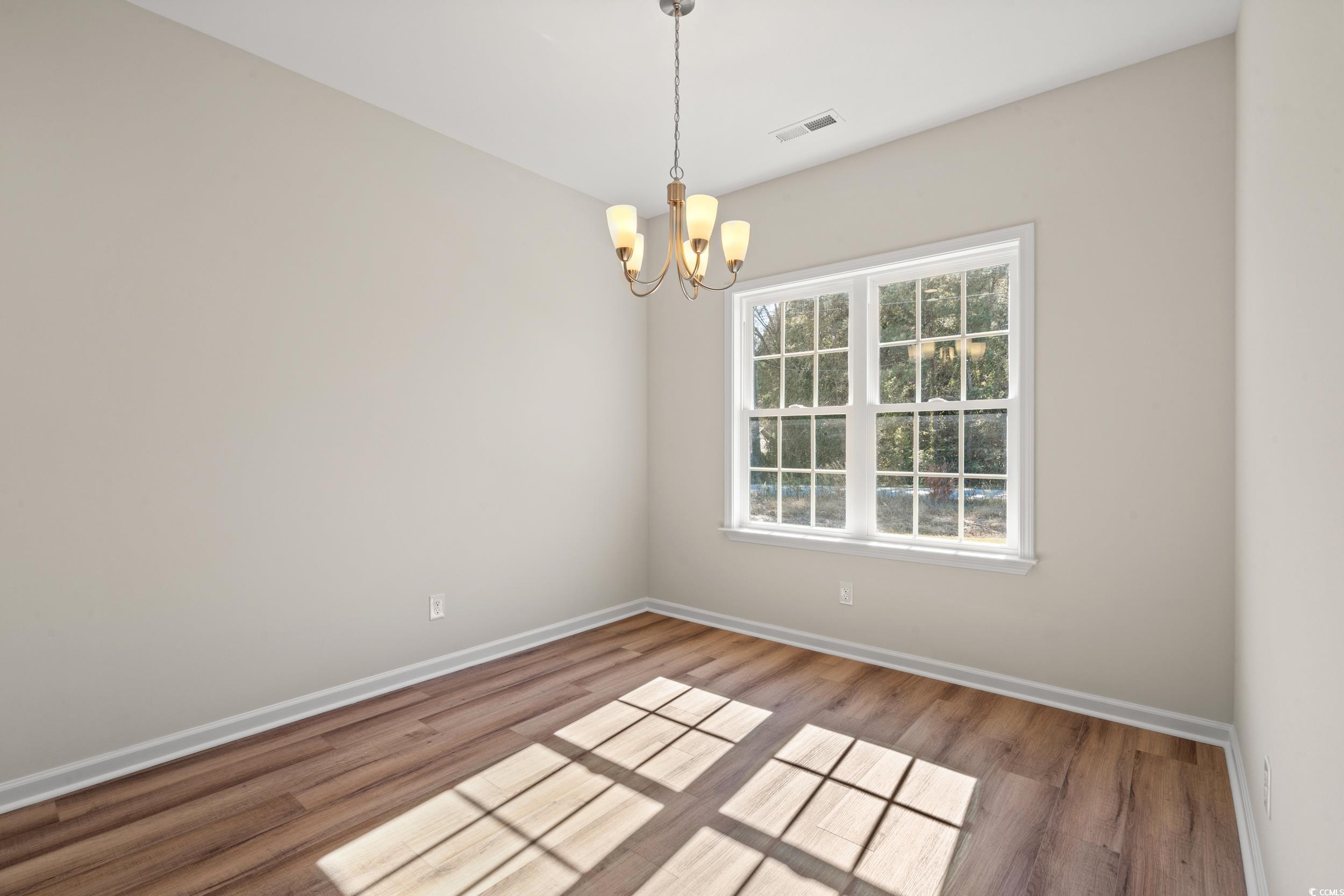 247 Stillbrook Drive Longs, SC 29568 - Photo 17 of 36 Empty room featuring light wood-type flooring and a chandelier