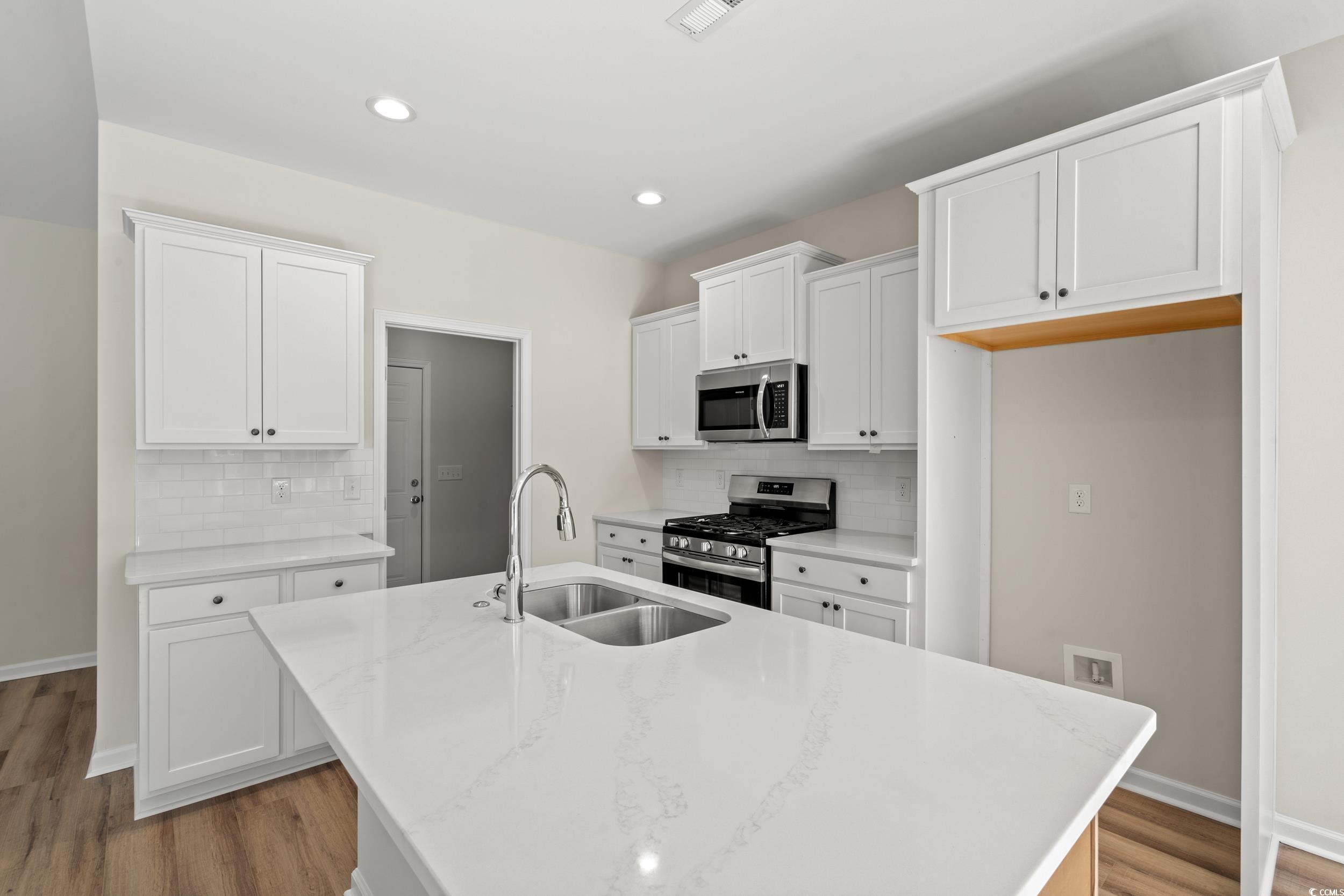 247 Stillbrook Drive Longs, SC 29568 - Photo 35 of 36 Kitchen with stainless steel appliances, white cabinets, light wood-style floors, a kitchen island with sink, and recessed lighting