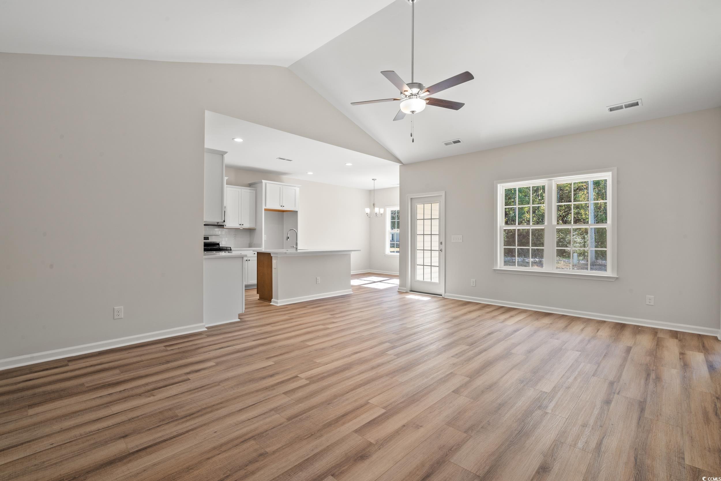 247 Stillbrook Drive Longs, SC 29568 - Photo 8 of 36 Unfurnished living room featuring light wood-style flooring, a chandelier, a ceiling fan, and high vaulted ceiling