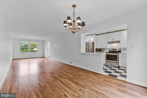 a view of a kitchen with wooden floor and a ceiling fan