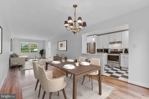 a view of a dining room with furniture a chandelier and wooden floor
