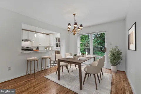 a dining room with furniture a rug and a floor to ceiling window