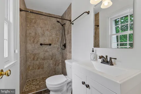 a bathroom with a sink toilet a mirror and shower