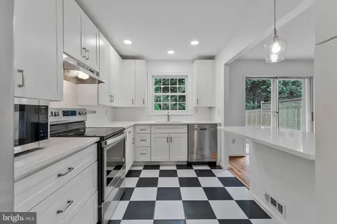 a kitchen with a stove a sink and a window