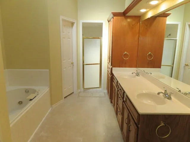 a bathroom with a tub sink and mirror
