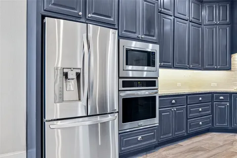 a kitchen with stainless steel appliances granite countertop a refrigerator and a stove top oven