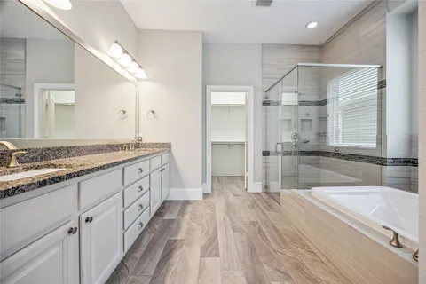 a spacious bathroom with a granite countertop sink mirror and a bathtub