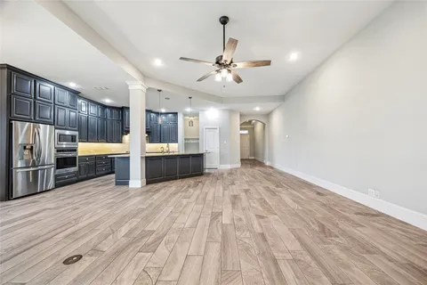 a view of a kitchen with a refrigerator and a stove top oven