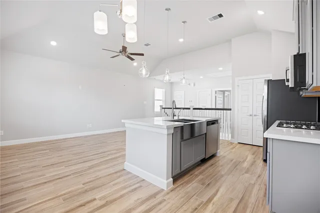 a kitchen with kitchen island a sink stainless steel appliances and cabinets