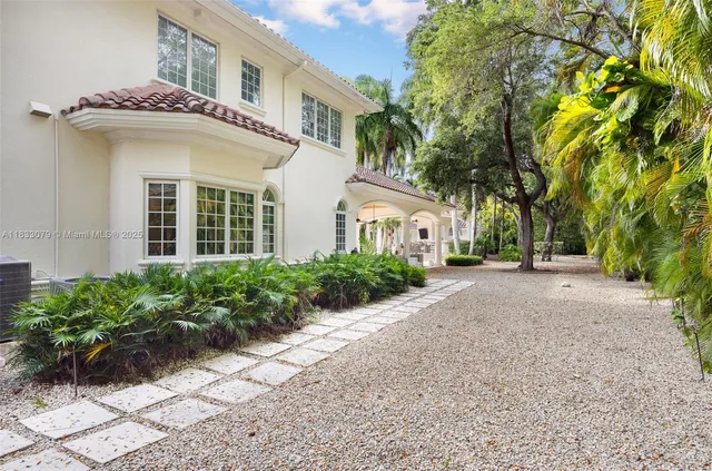 a view of a white house with a yard and plants