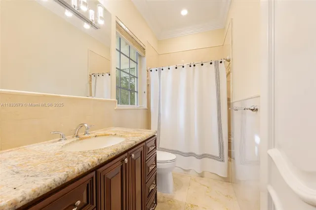 a bathroom with a granite countertop sink a toilet and bathtub