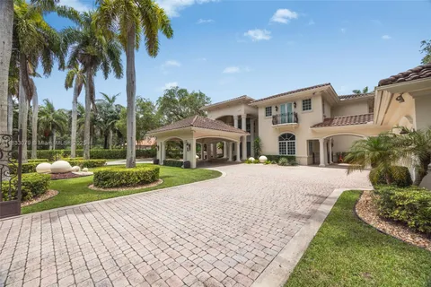 a front view of a house with a yard and potted plants