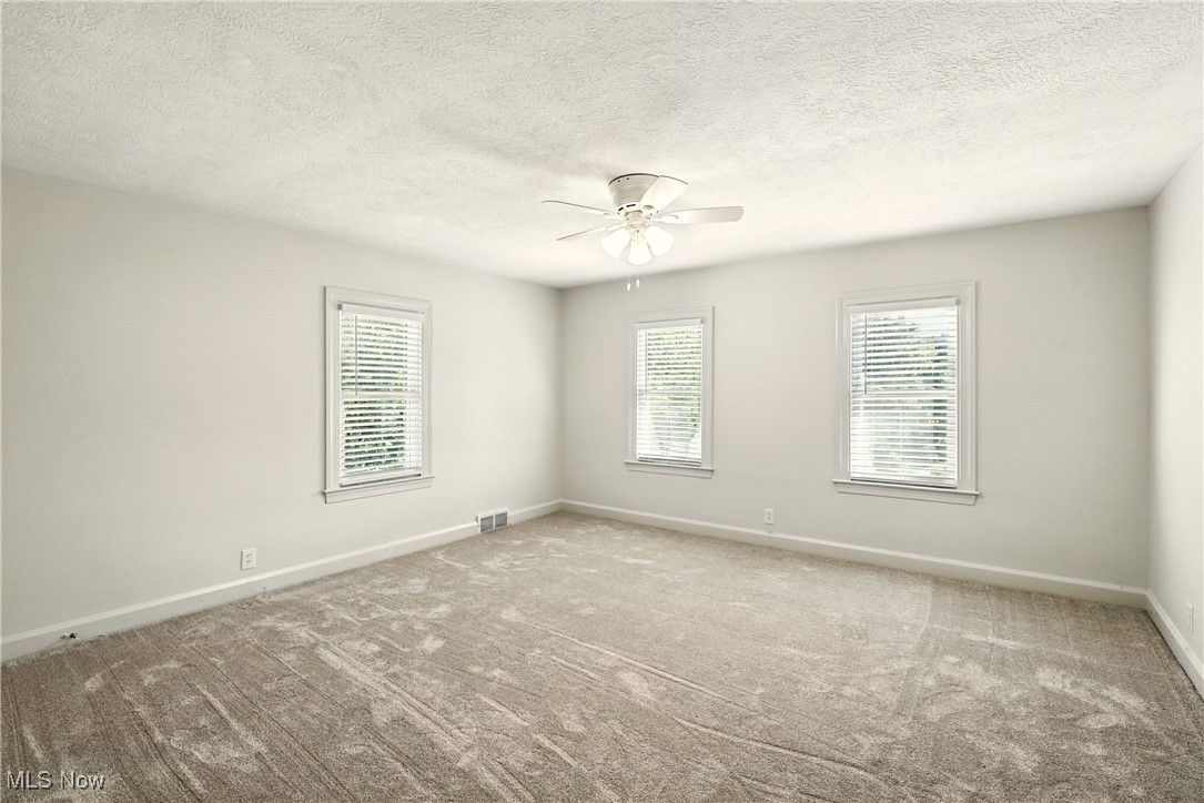 2844 Kent Road Stow, OH 44224 - Photo 27 of 47 Unfurnished room featuring plenty of natural light, a textured ceiling, carpet flooring, and a ceiling fan