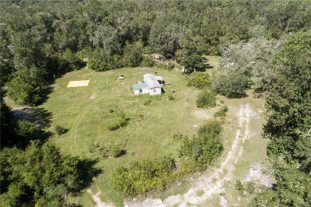 a aerial view of a residential houses with yard