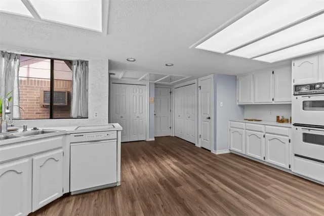 a kitchen with white cabinets and sink