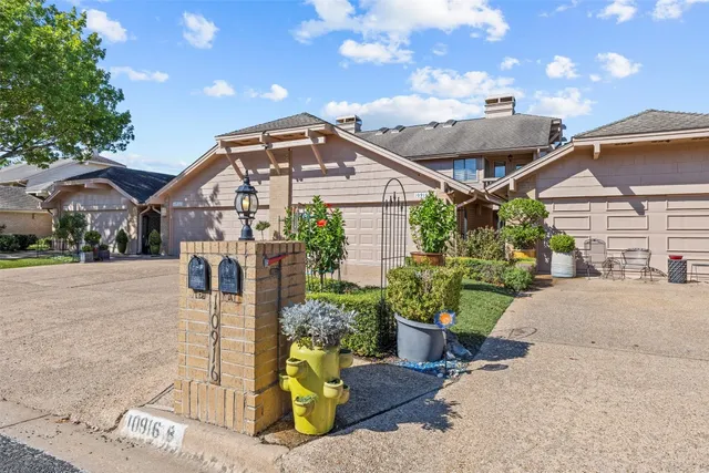 a front view of a house with a yard and potted plants