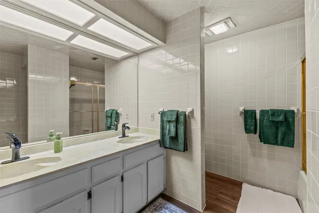 a bathroom with a double vanity sink and shower