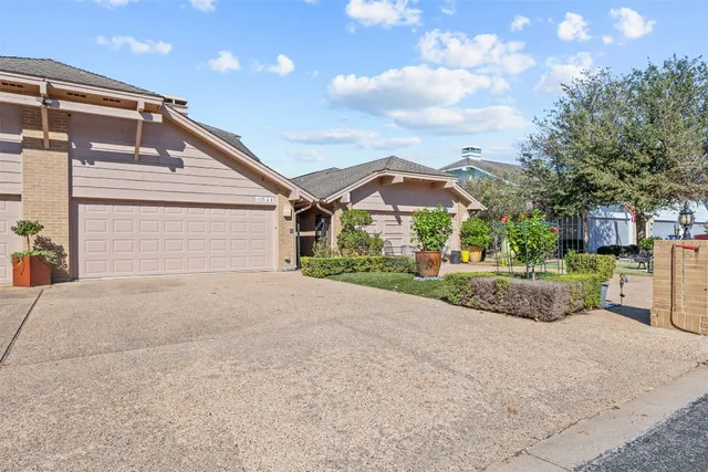 a view of a house with a yard and potted plants
