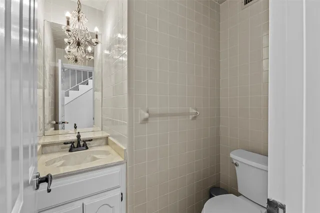 a bathroom with a granite countertop sink a toilet and shower