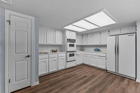 a kitchen with white cabinets and white appliances