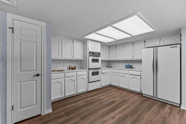 a kitchen with white cabinets and white appliances
