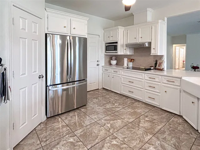 a kitchen with stainless steel appliances a refrigerator sink and cabinets